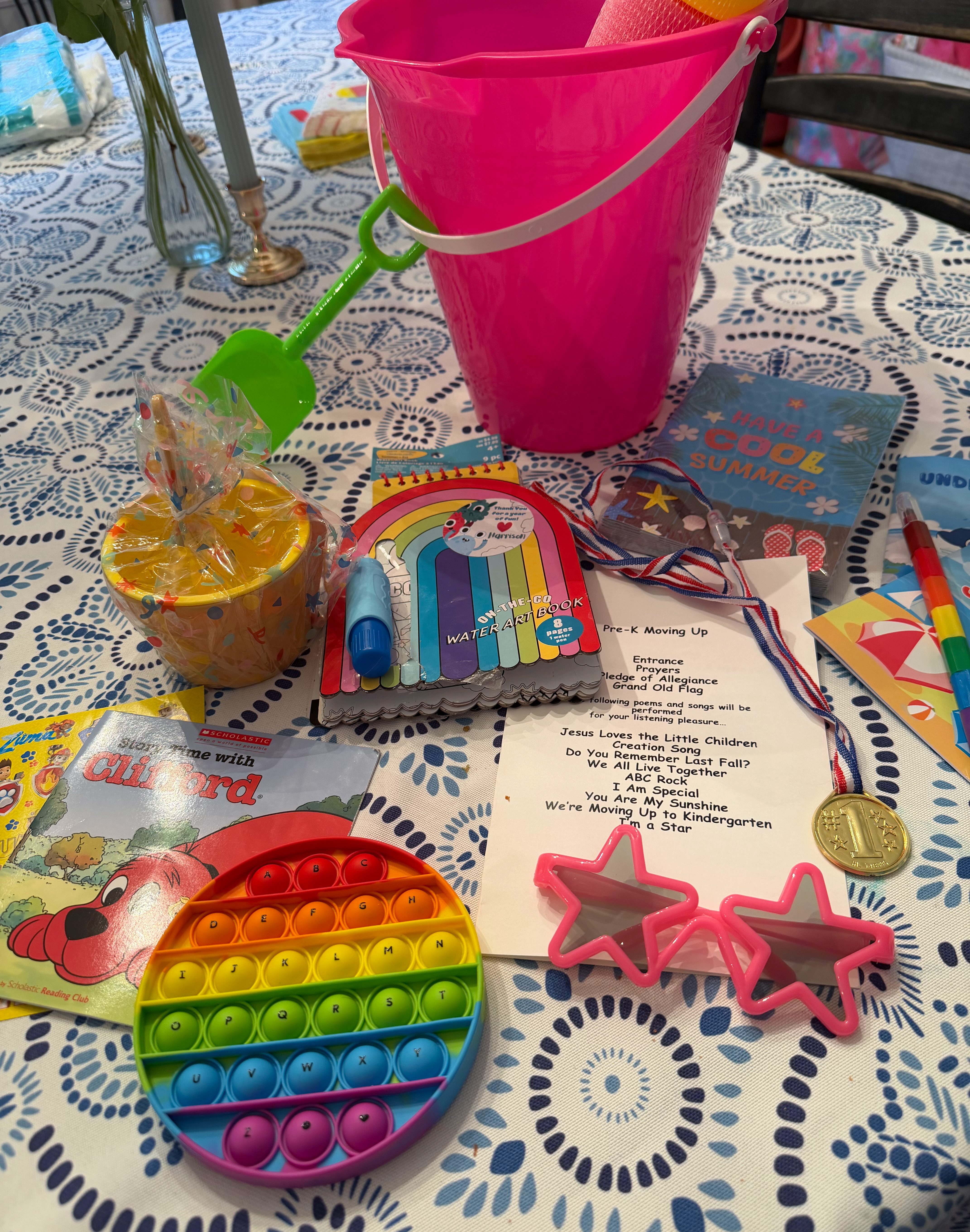 Pre-K graduation bucket items spread across a table before being sorted into summer pool bag activities.